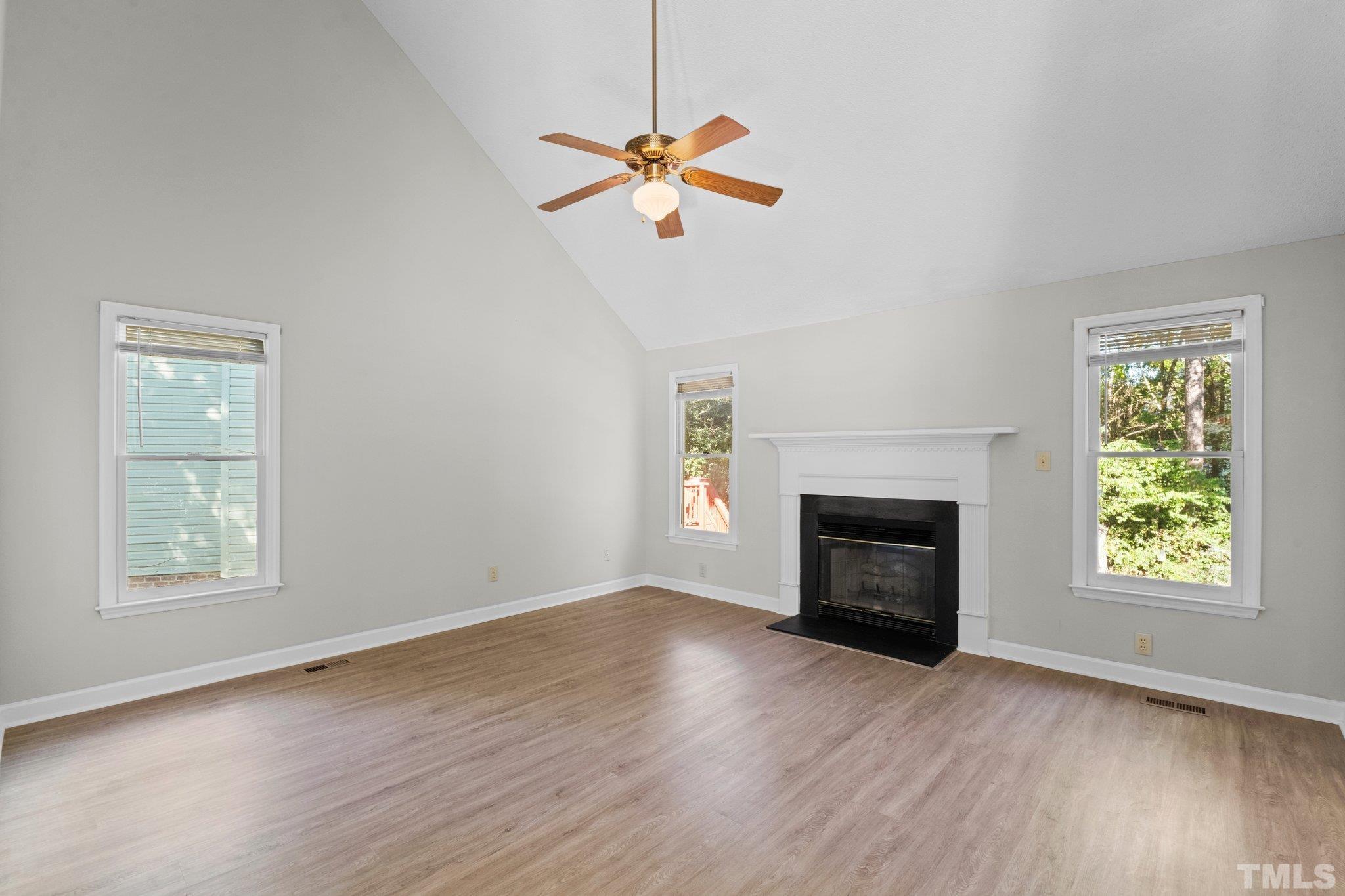 4405 Birmingham Way Raleigh, NC 27604 - Photo 8 of 22 an empty room with windows fireplace and wooden floor