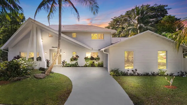 a view of a house with backyard and sitting area