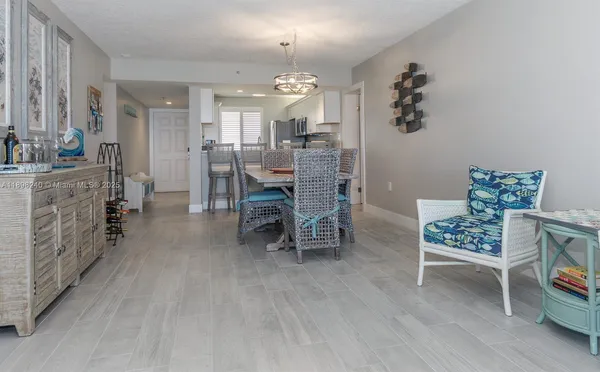 a living room with furniture a flat screen tv and a floor to ceiling window