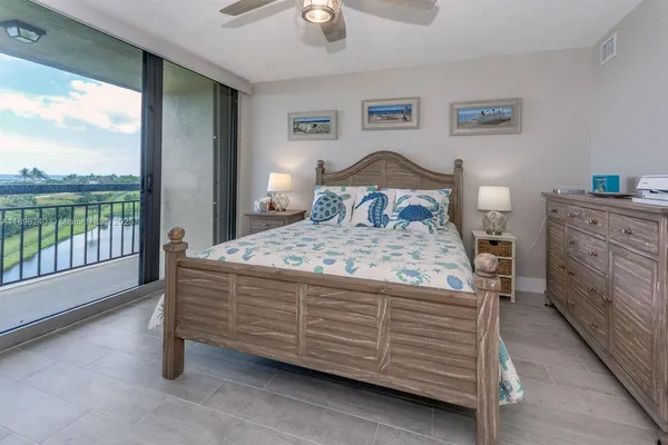 a bedroom with a bed and large windows