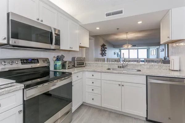 a kitchen with cabinets stainless steel appliances and sink