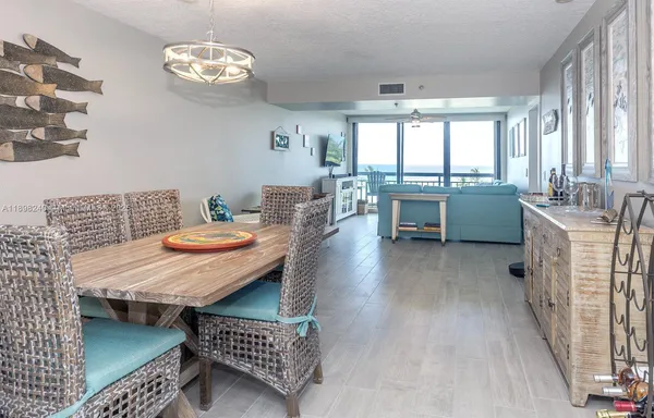 a dining room with furniture a rug a fireplace and a chandelier