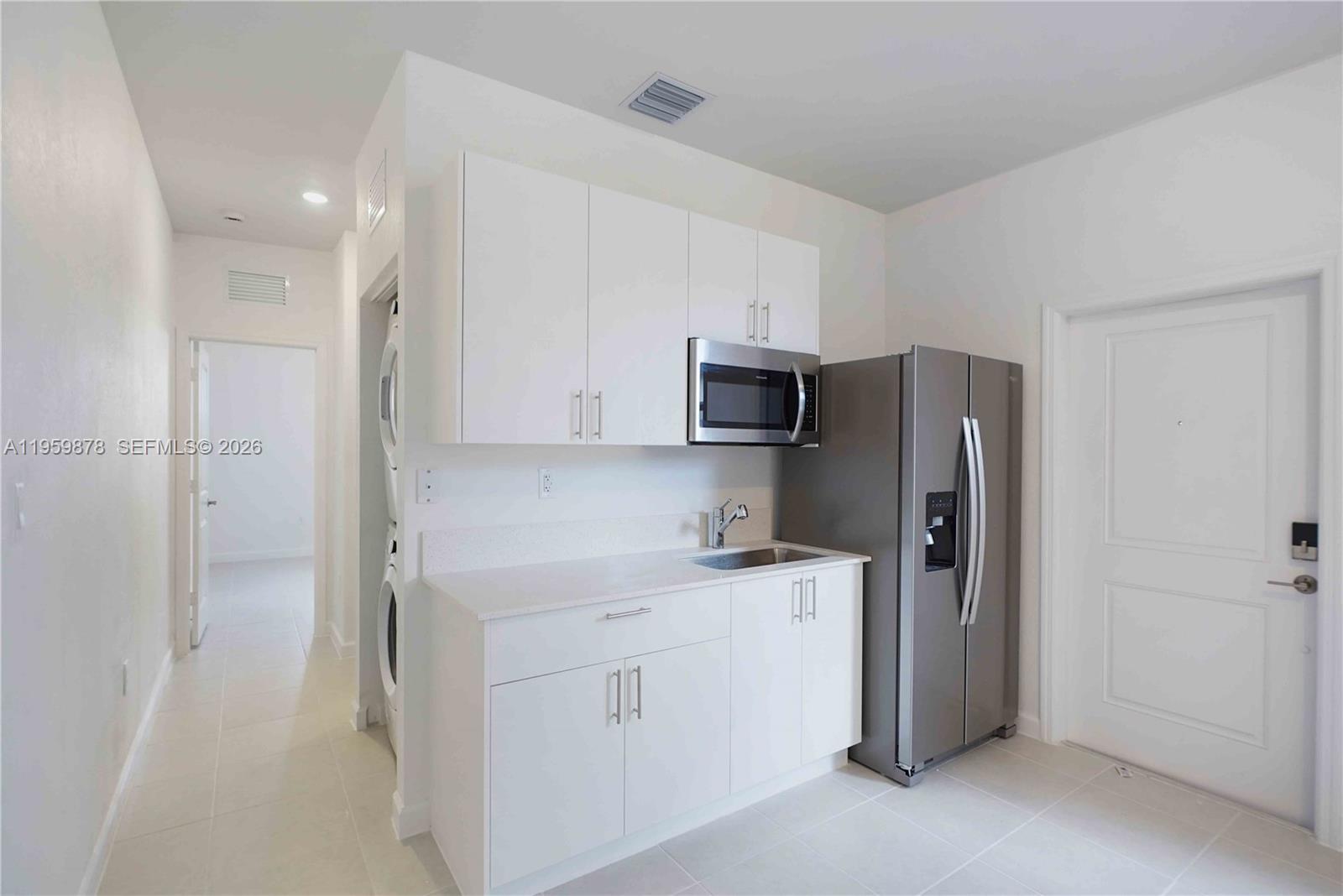 13621 Southwest 185th Lane, Unit A Miami, FL 33177 - Photo 5 of 9 a kitchen with stainless steel appliances a refrigerator sink and cabinets