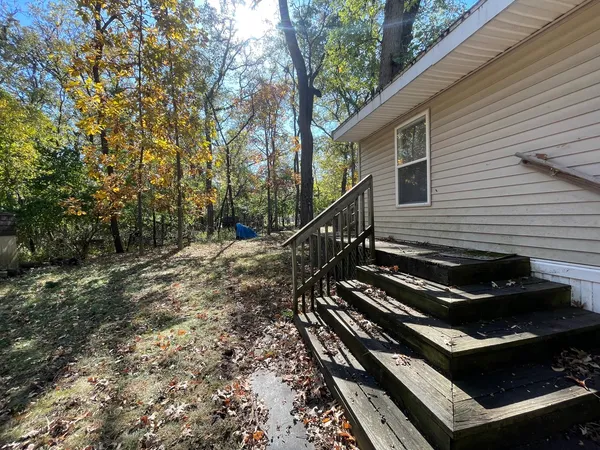 a backyard of a house with wooden fence and trees