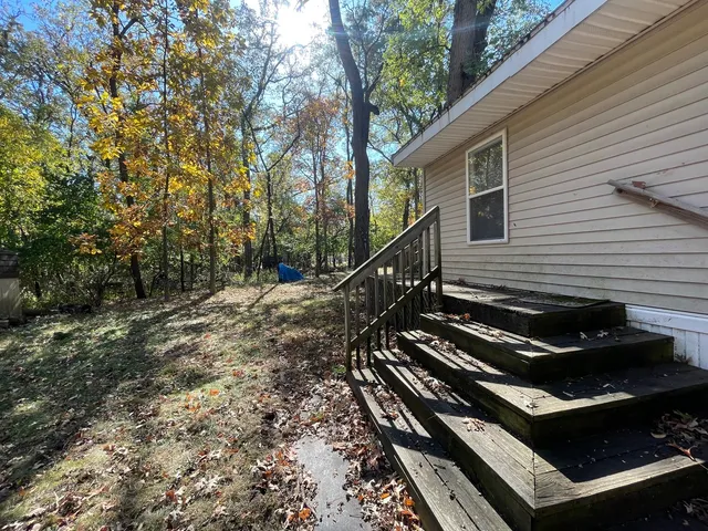 a backyard of a house with wooden fence and trees