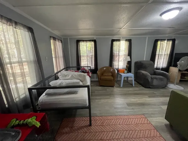 a living room with furniture fireplace and large windows