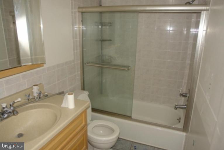 2109 Walsh View Terrace, Unit 301 Silver Spring, MD 20902 - Photo 3 of 4 a bathroom with a granite countertop bathtub shower sink vanity and toilet
