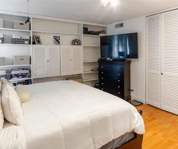 a bedroom with a bed and a flat tv screen