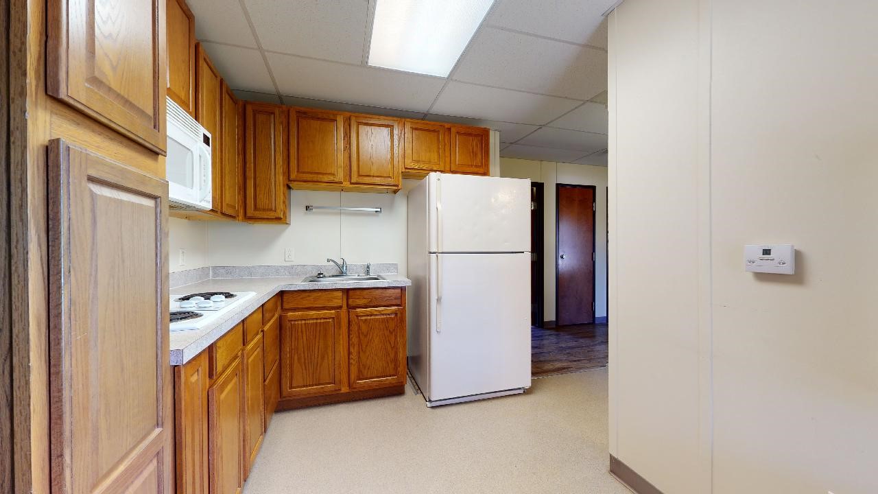 5585 Straub Road College Station, TX 77845 - Photo 28 of 50 a kitchen with refrigerator a microwave and cabinets