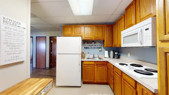 a kitchen with a sink a refrigerator and cabinets