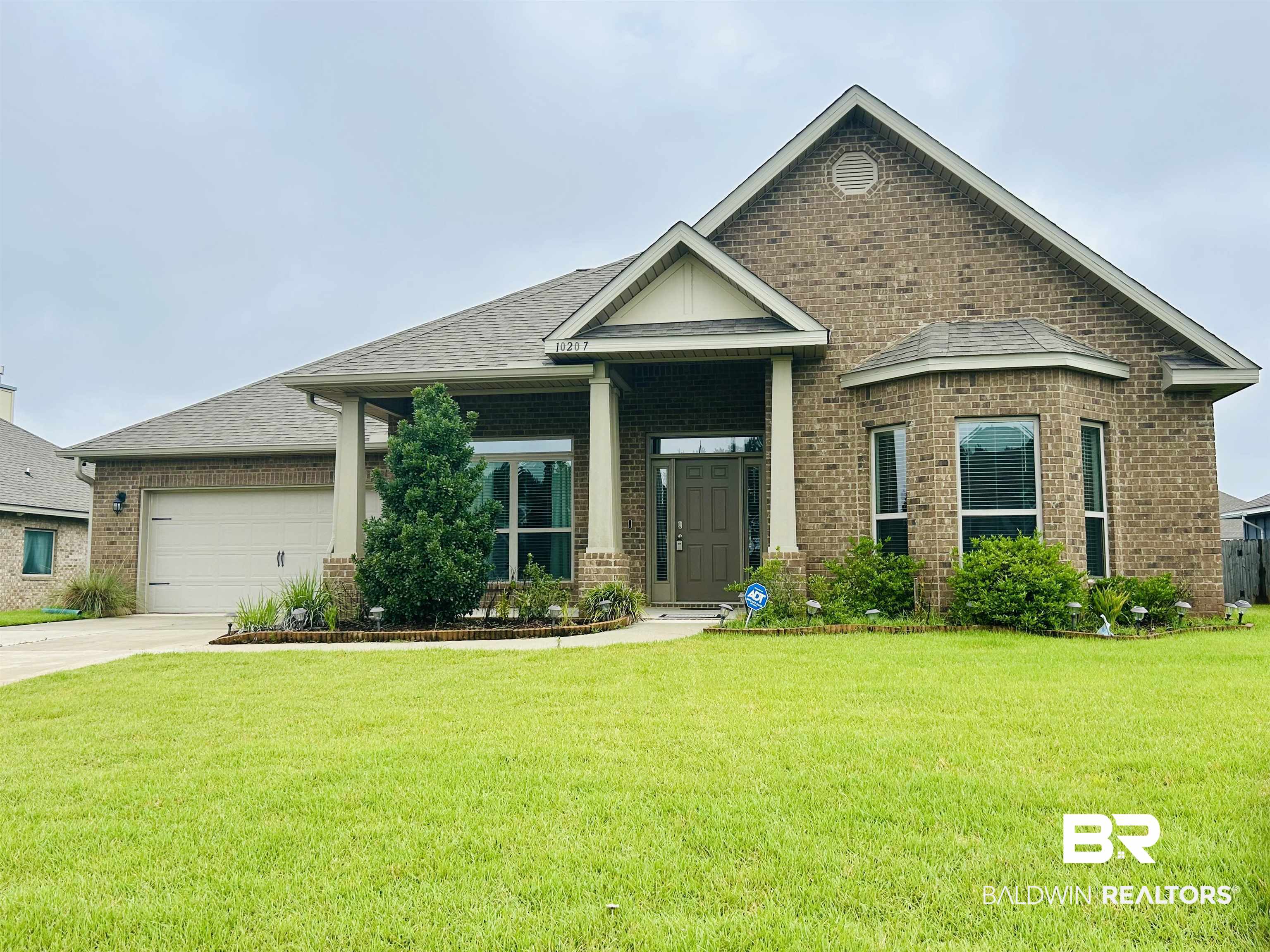 10207 Dunleith Loop Daphne, AL 36526 - Photo 1 of 23 Craftsman house with brick siding, a front yard, an attached garage, concrete driveway, and a shingled roof