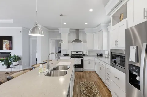 a large white kitchen with cabinets a stove a sink and a stove