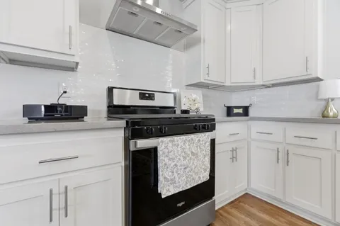 a kitchen with white cabinets and appliances