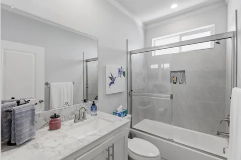 a bathroom with a granite countertop tub sink toilet and shower