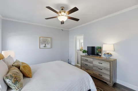 a bedroom with a bed and a flat tv screen on dresser