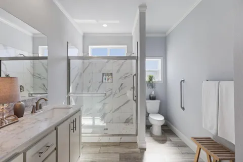 a bathroom with a granite countertop sink a toilet and shower