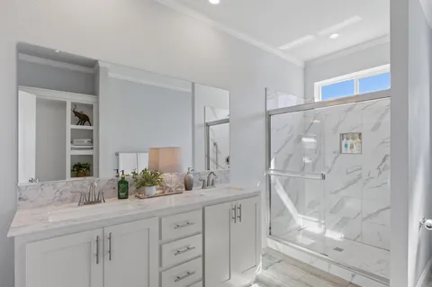 a bathroom with a granite countertop sink mirror and a shower