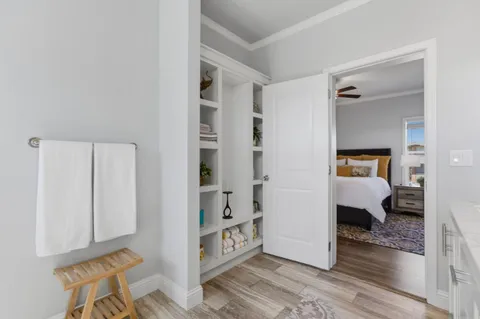 a view of a bedroom with wooden floor and furniture