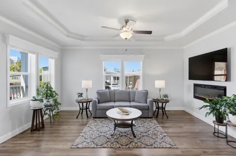 a living room with furniture a rug a window and a flat screen tv