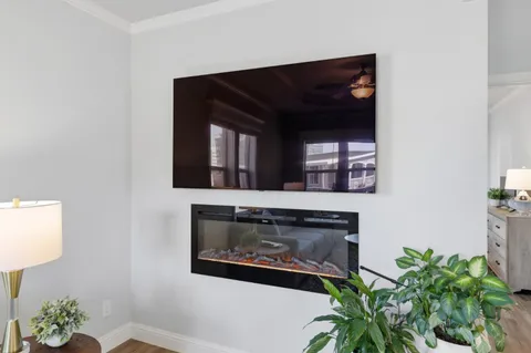 a living room with a fireplace and a potted plant
