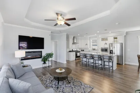 a living room with furniture a dining table and a flat screen tv