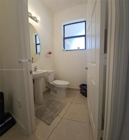 a bathroom with a toilet a sink and mirror