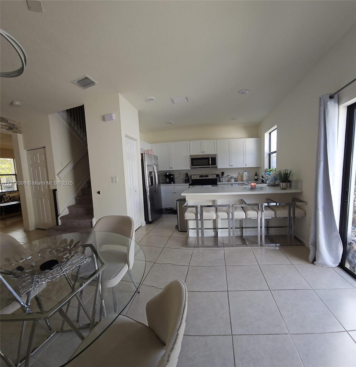 3387 West 106th Terrace, Unit 3387 Hialeah, FL 33018 - Photo 5 of 20 a kitchen with stainless steel appliances a stove a sink a microwave and a refrigerator