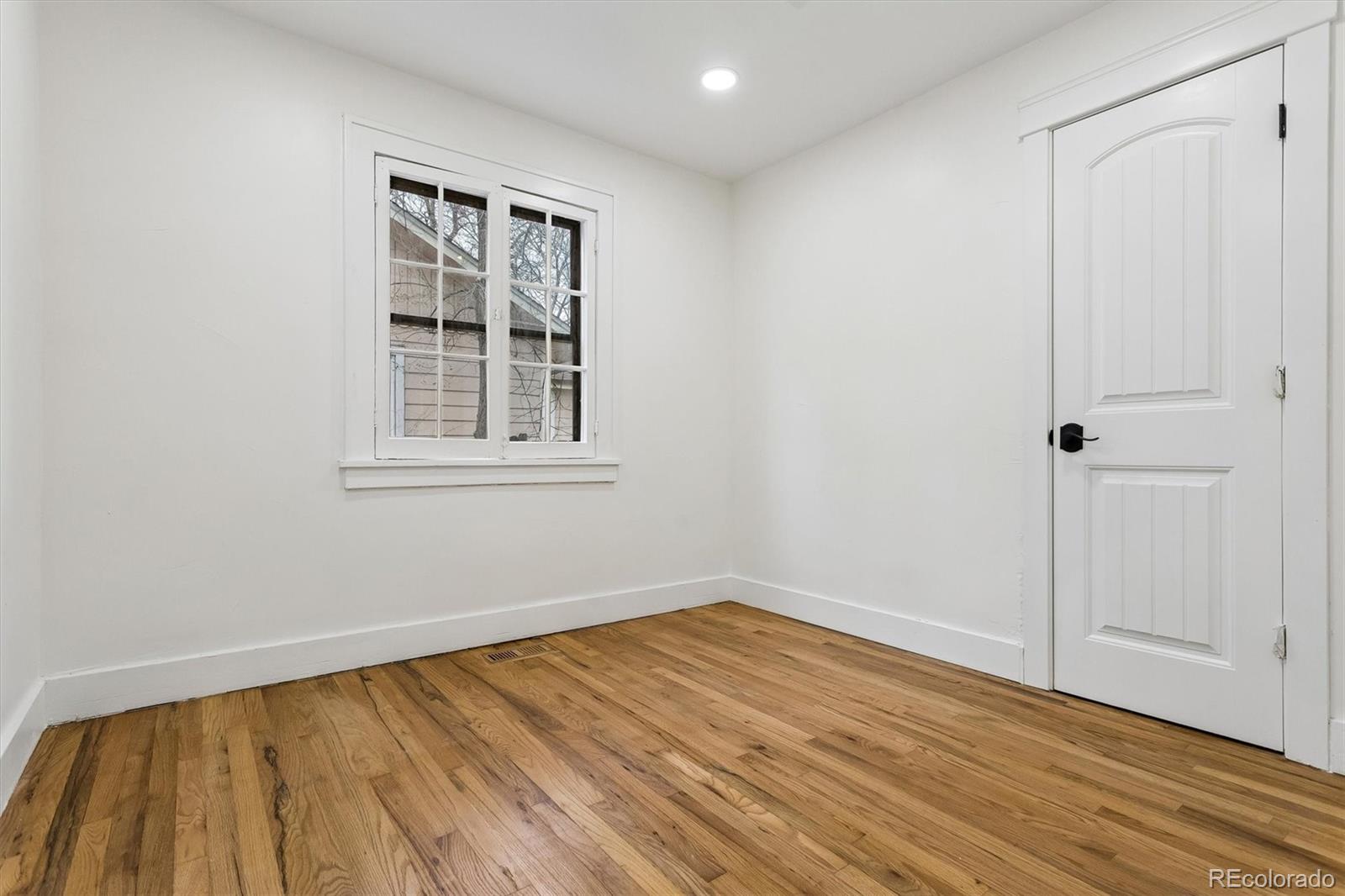 2293 Fenton Street Edgewater, CO 80214 - Photo 8 of 18 a view of an empty room with wooden floor and a window