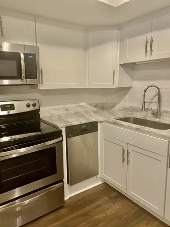 a kitchen with granite countertop a stove and a sink