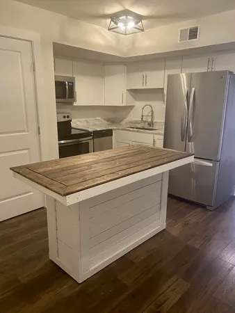 a view of a refrigerator in kitchen and wooden floor