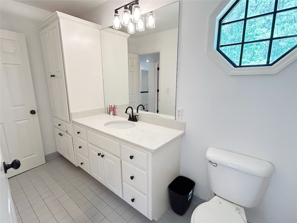 2004 Moores Mill Road Lanett, AL 36863 - Photo 41 of 50 This bathroom features an elegant vanity with ample storage and a unique octagonal window.