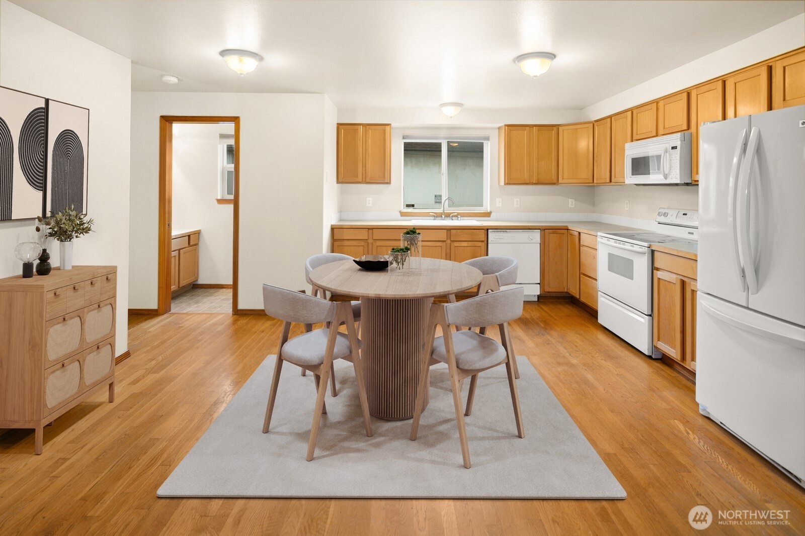 1417 North 97th Street Seattle, WA 98103 - Photo 5 of 23 a kitchen with stainless steel appliances granite countertop a refrigerator a sink a stove and white cabinets with wooden floor