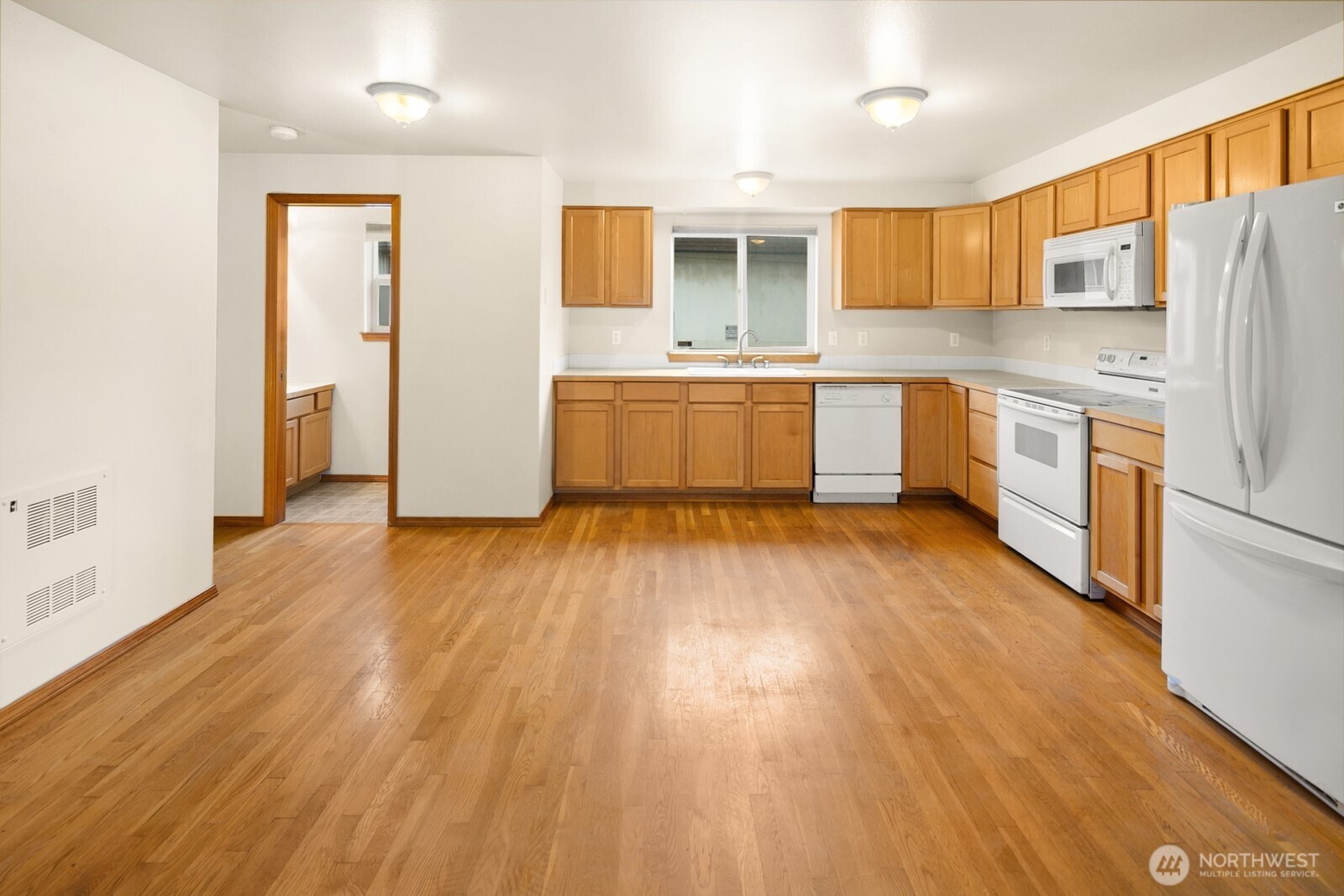 1417 North 97th Street Seattle, WA 98103 - Photo 6 of 23 a kitchen with a refrigerator a sink and cabinets