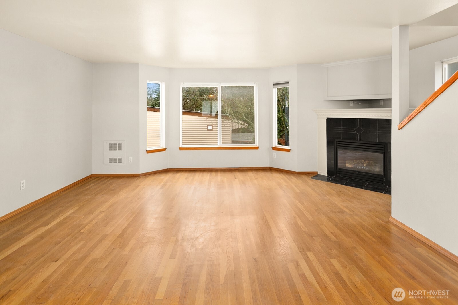 1417 North 97th Street Seattle, WA 98103 - Photo 9 of 23 a view of empty room with wooden floor and fireplace