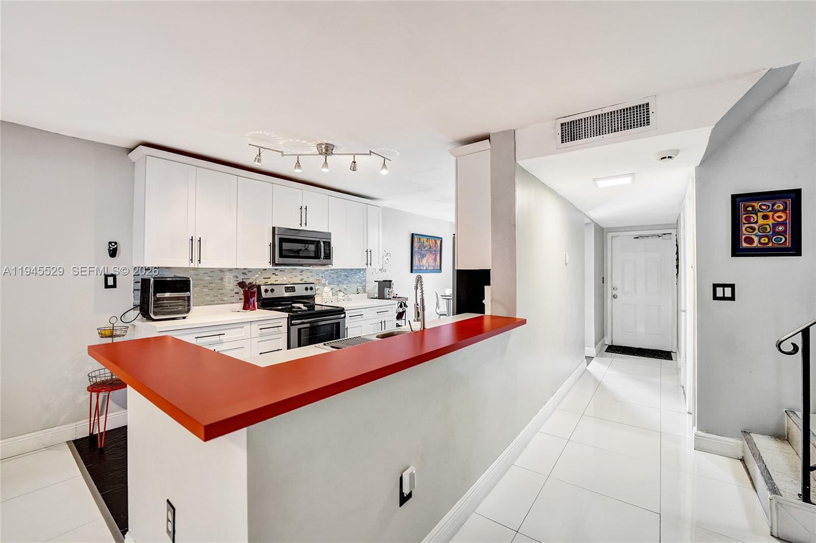 3301 Raleigh Street, Unit 4E Hollywood, FL 33021 - Photo 26 of 80 a kitchen with stainless steel appliances a stove refrigerator sink and cabinets