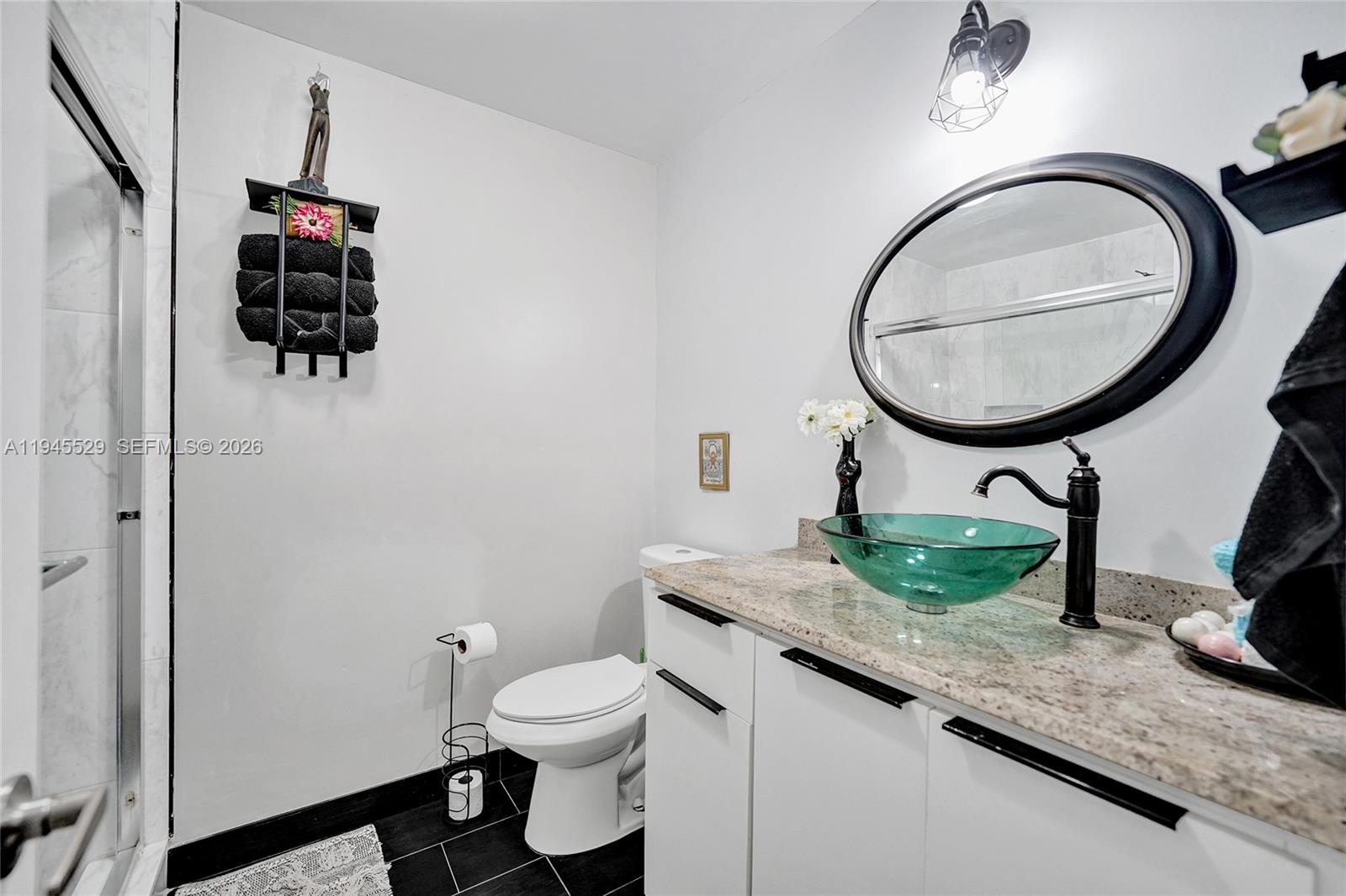 3301 Raleigh Street, Unit 4E Hollywood, FL 33021 - Photo 56 of 80 a bathroom with a granite countertop toilet sink and mirror