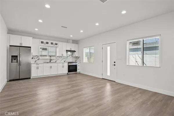 a view of kitchen with wooden cabinet and refrigerator
