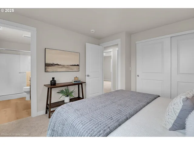 a bedroom with a bed a table and painting