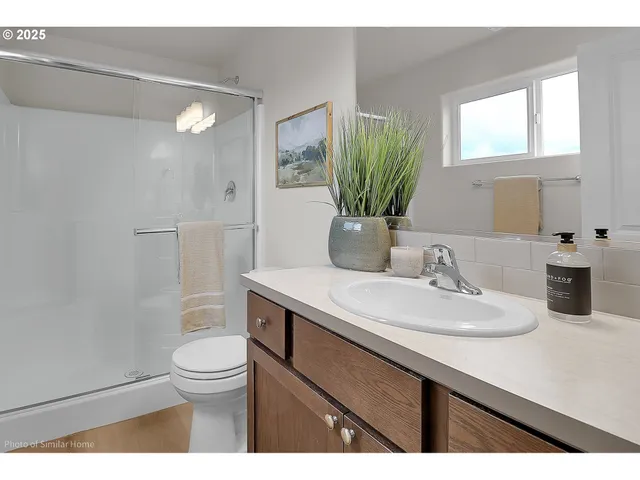a bathroom with a granite countertop sink a toilet and a mirror