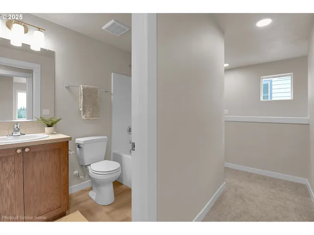 a bathroom with a toilet sink a mirror and vanity