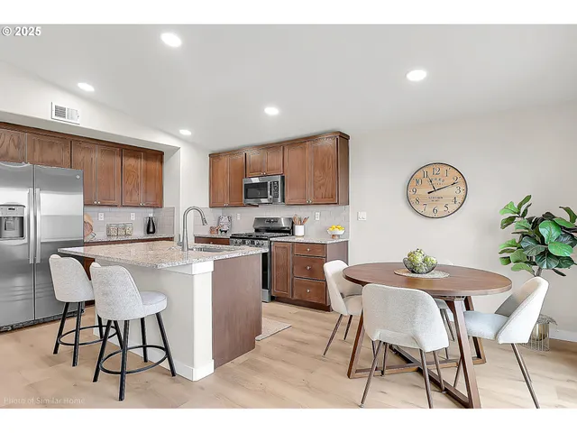 a kitchen with a dining table cabinets and chairs