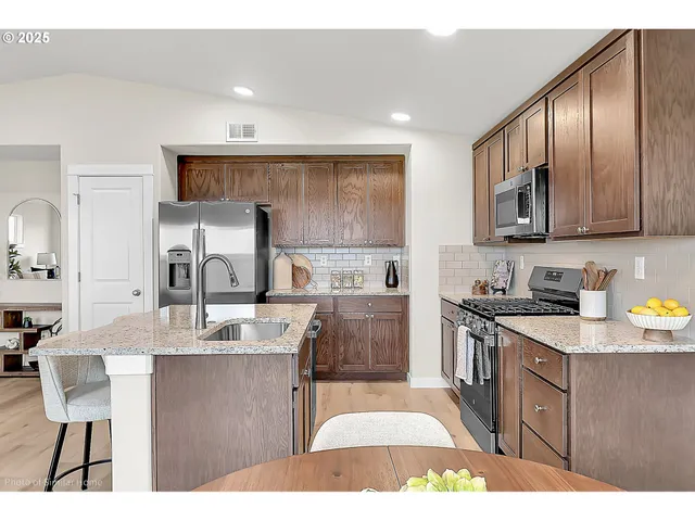 a kitchen with stainless steel appliances granite countertop a sink stove and cabinets