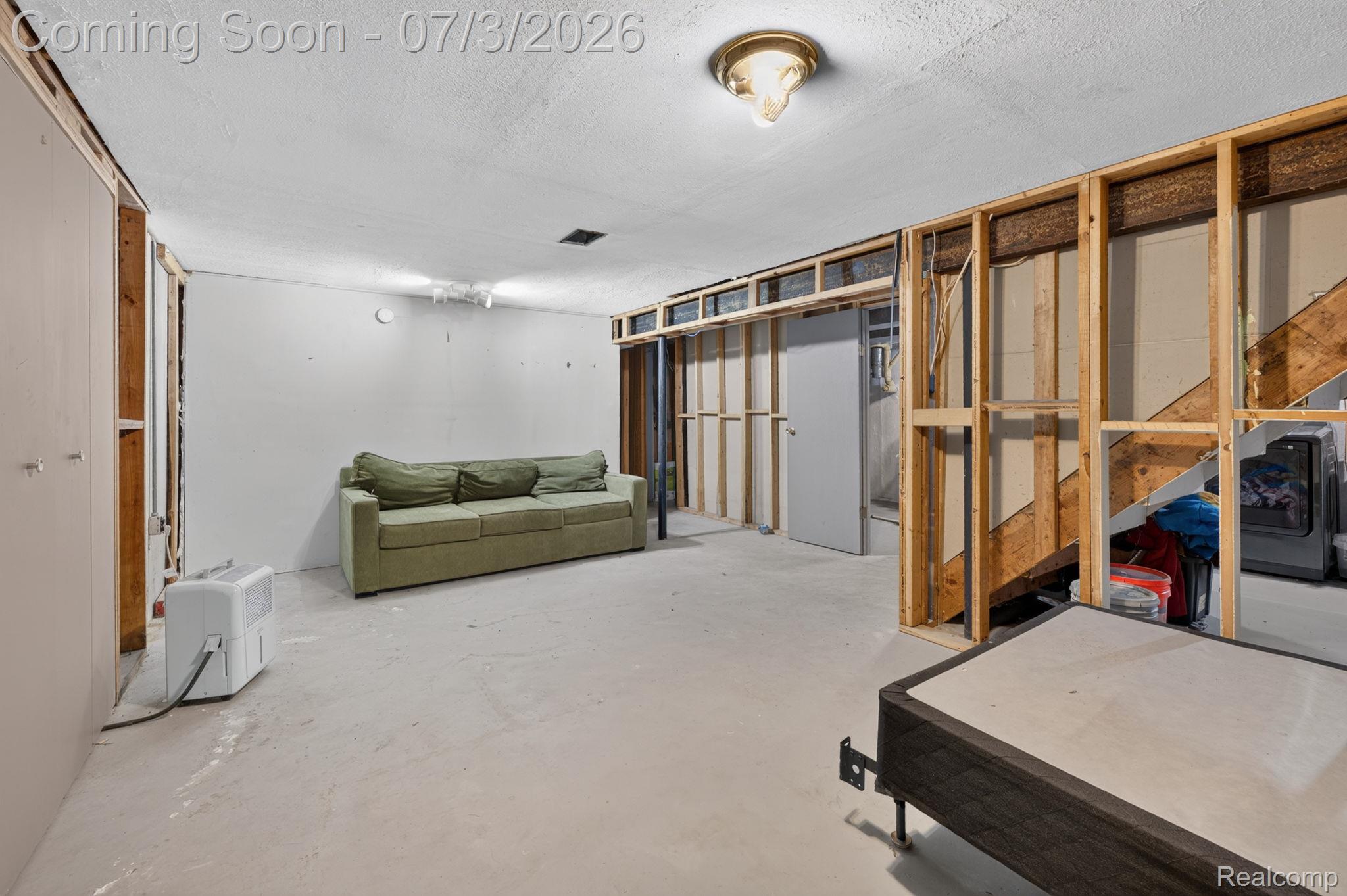5355 North Seymour Road Flushing, MI 48433 - Photo 34 of 41 Unfinished basement featuring exposed framing, concrete flooring, and a ceiling-mounted light fixture