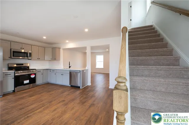 a kitchen with stainless steel appliances kitchen island wooden cabinets and entryway