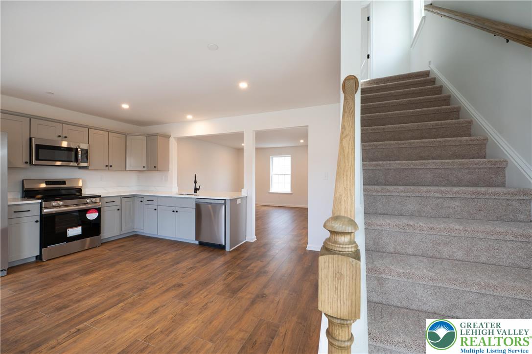 560 Long Street, Unit 4 Emmaus, PA 18049 - Photo 5 of 16 a kitchen with stainless steel appliances kitchen island wooden cabinets and entryway