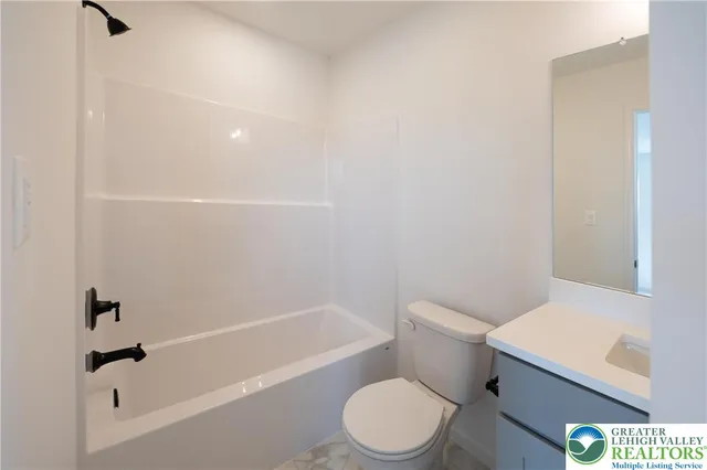 a white toilet and tub sitting next to a bathroom sink