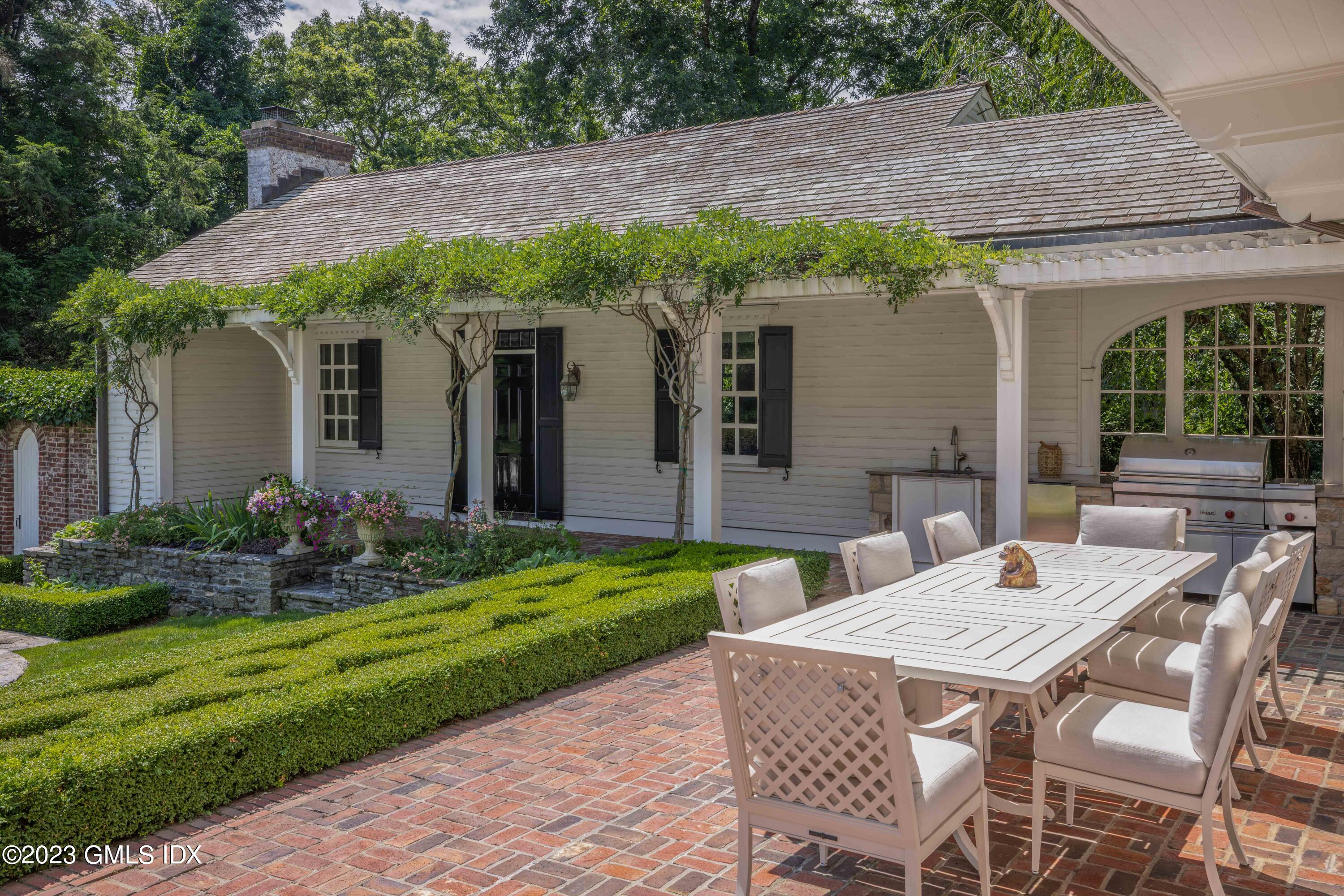 80 Round Hill Road Greenwich, CT 06831 - Photo 42 of 57 a view of a patio with table and chairs under an umbrella