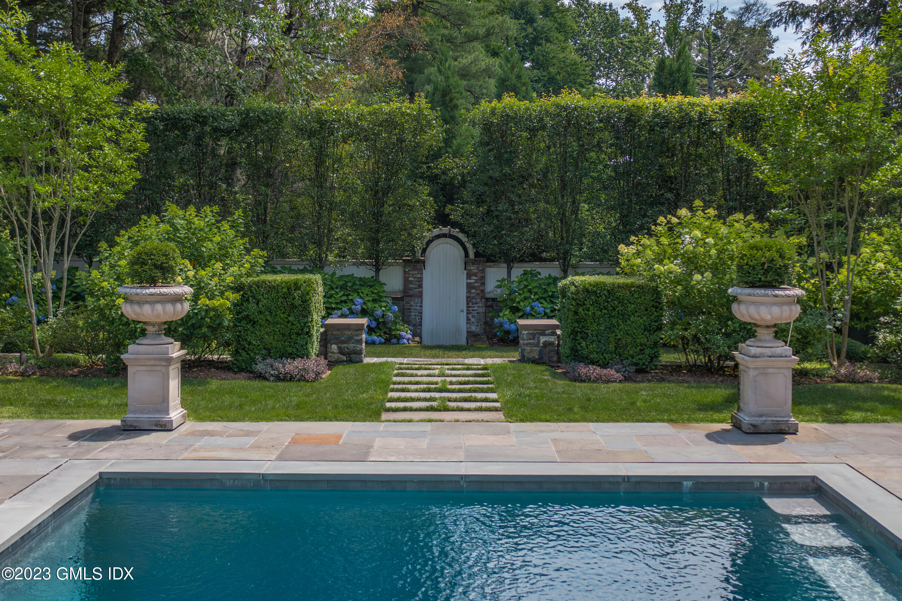 80 Round Hill Road Greenwich, CT 06831 - Photo 51 of 57 a front view of a house with garden and plants