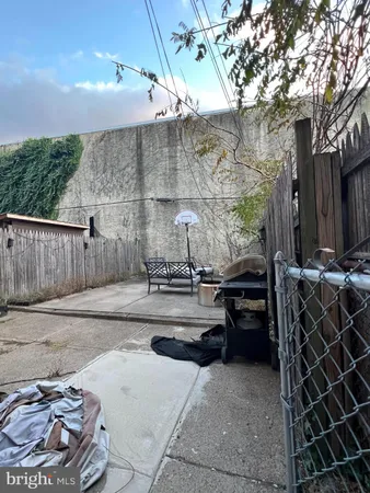 a view of a patio with table and chairs with wooden fence and plants