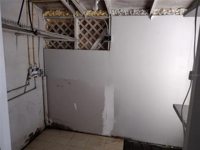 a view of a house with a wooden fence and a tree